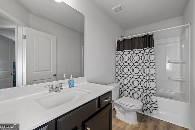 full bathroom featuring shower / bath combination with curtain, visible vents, toilet, vanity, and wood finished floors