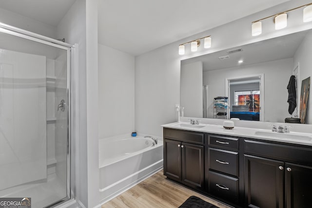 ensuite bathroom featuring double vanity, a stall shower, and a sink