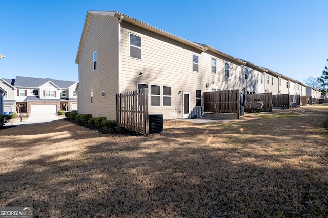 rear view of property featuring a residential view, fence, and a yard