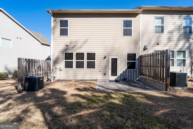 back of house featuring a patio area, fence, central AC unit, and a yard