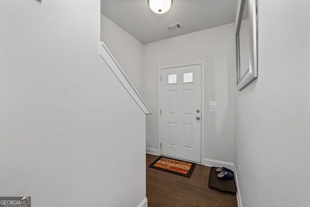 foyer entrance featuring visible vents, baseboards, and wood finished floors