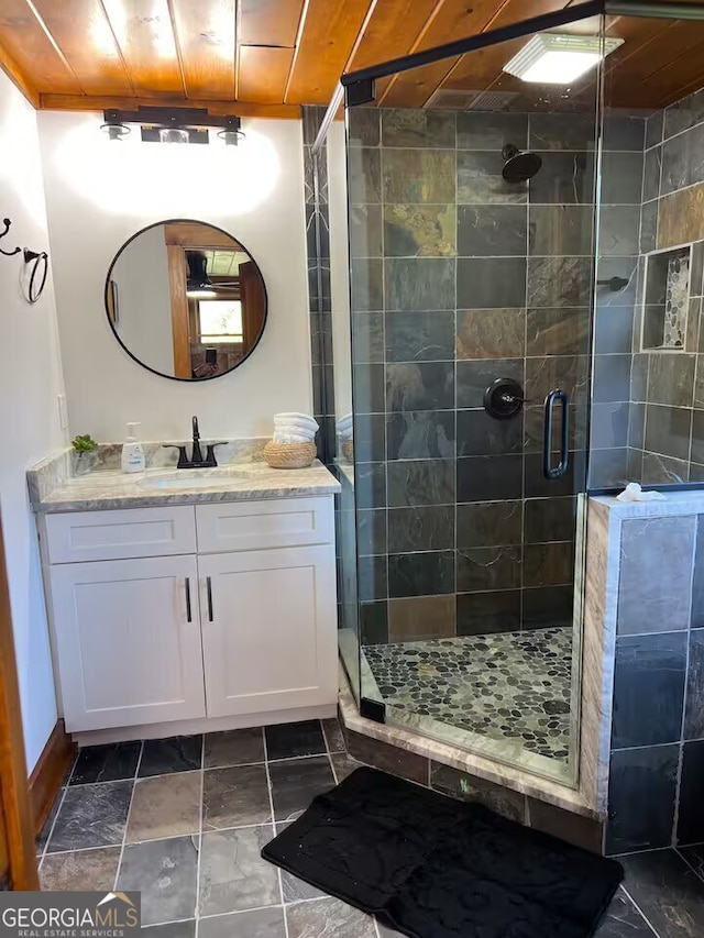 bathroom with vanity and a shower with door