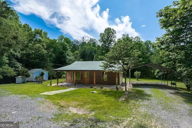 view of front of property with covered porch, a front lawn, a carport, and a storage shed