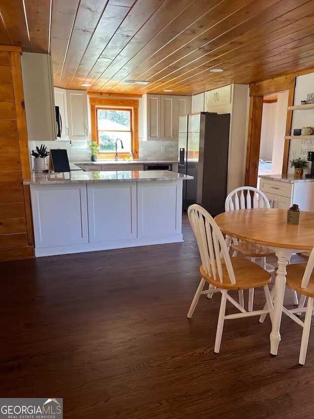 kitchen featuring kitchen peninsula, wood ceiling, dark hardwood / wood-style floors, and stainless steel fridge with ice dispenser