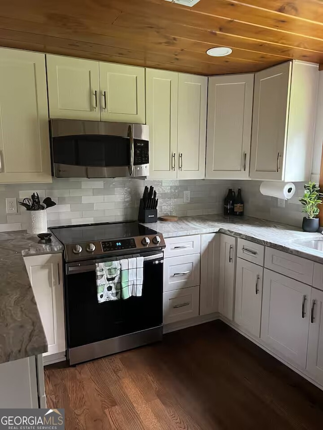 kitchen with range with electric cooktop, dark wood-type flooring, white cabinets, and decorative backsplash