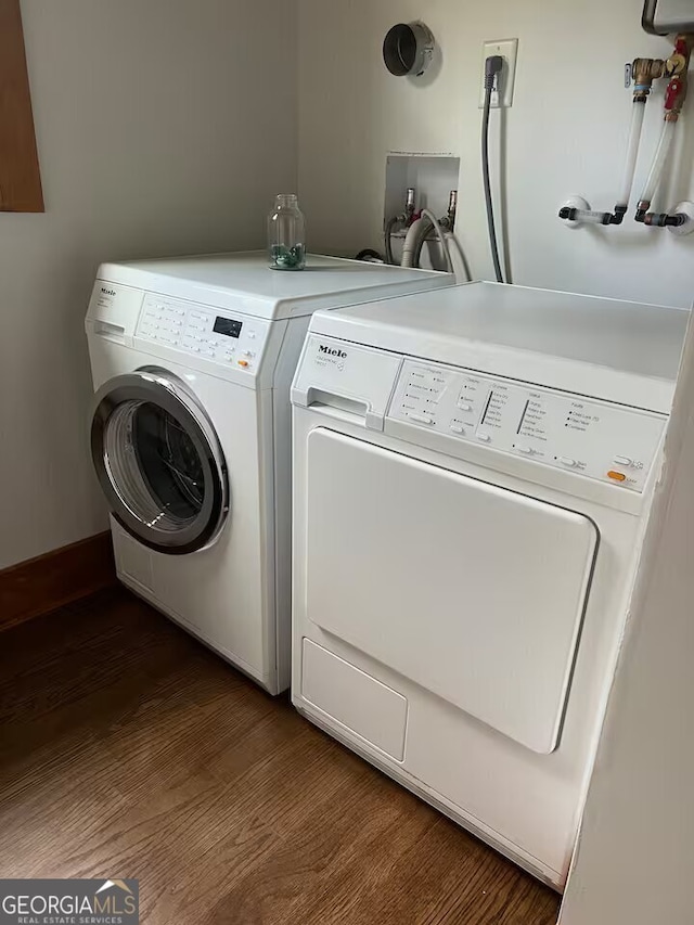 laundry room featuring dark wood-type flooring and separate washer and dryer