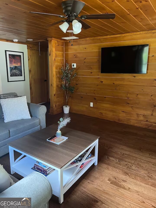 living room featuring ceiling fan, wood ceiling, wood walls, and hardwood / wood-style floors