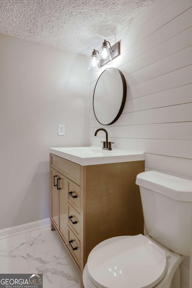 4419 New Kings Bridge Rd, Nicholson, GA 30565 - bathroom with vanity, toilet, marble finish floors, a textured ceiling, and baseboards