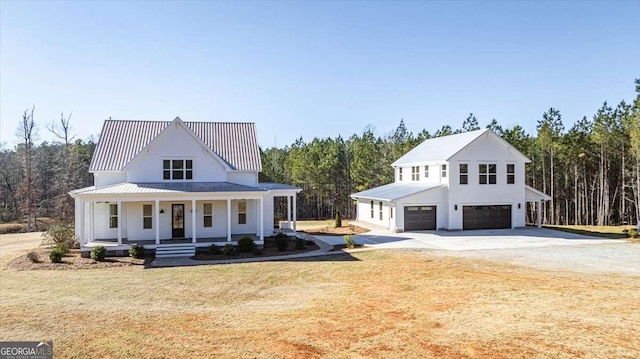 view of front facade with covered porch, a front yard, and a garage