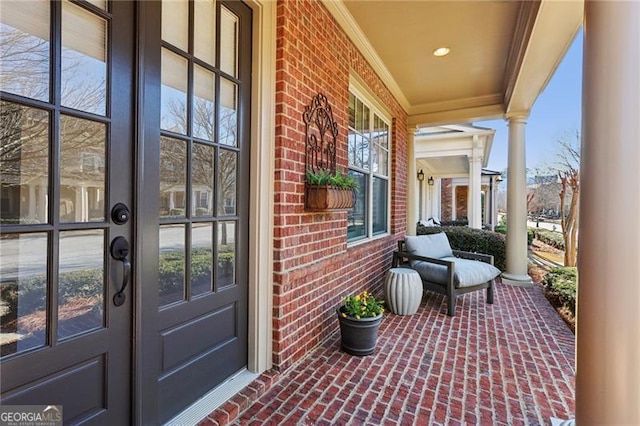 view of exterior entry with a porch and french doors