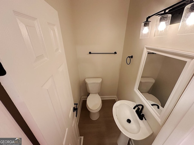 bathroom with toilet and hardwood / wood-style flooring