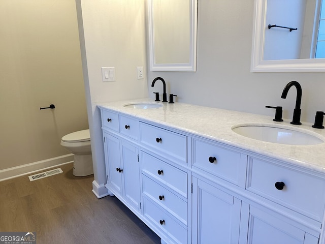 bathroom featuring wood-type flooring, vanity, and toilet