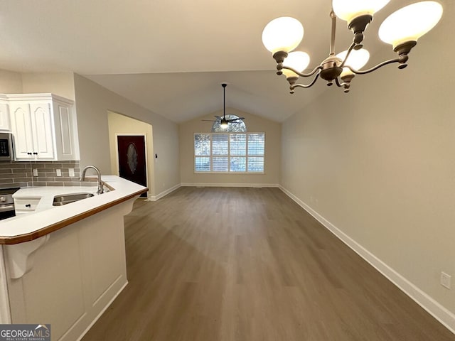 kitchen with white cabinets, decorative backsplash, pendant lighting, sink, and kitchen peninsula