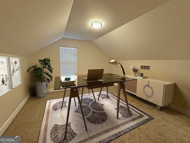 carpeted office with a textured ceiling and vaulted ceiling