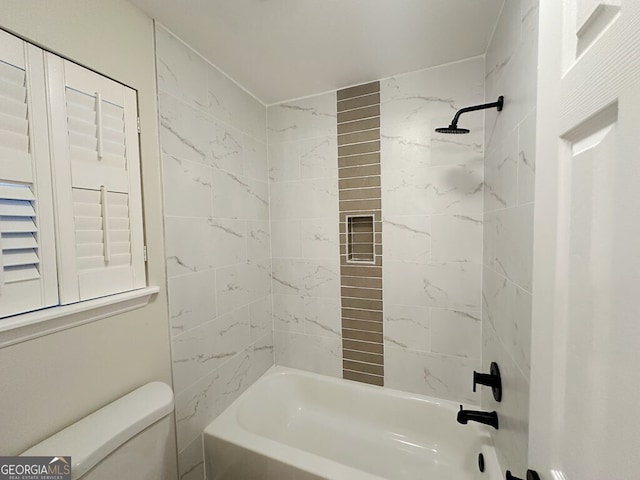 bathroom featuring toilet and tiled shower / bath