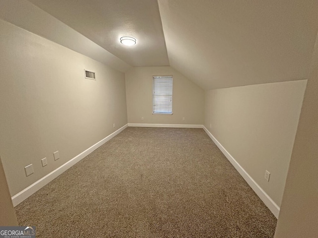 additional living space featuring carpet flooring and lofted ceiling