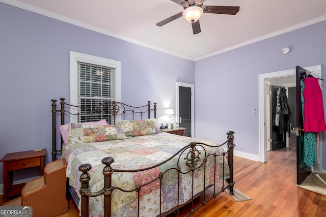 bedroom with ornamental molding, ceiling fan, and wood-type flooring