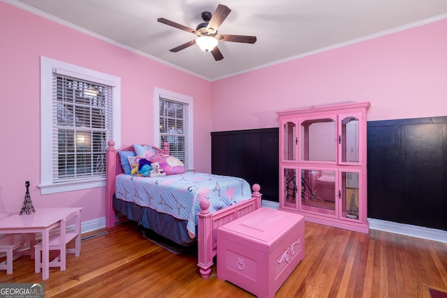 bedroom featuring hardwood / wood-style flooring, ceiling fan, and ornamental molding