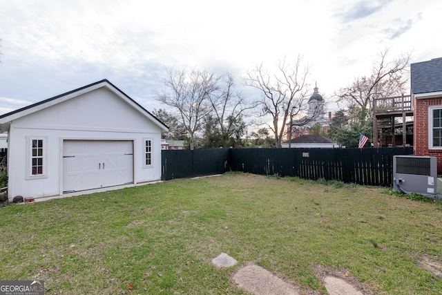 view of yard featuring a garage, central AC, and an outdoor structure