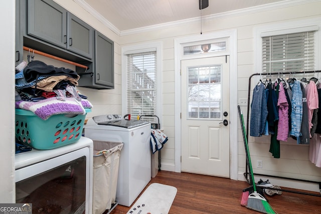 laundry room featuring cabinets, washer and clothes dryer, dark hardwood / wood-style flooring, and crown molding