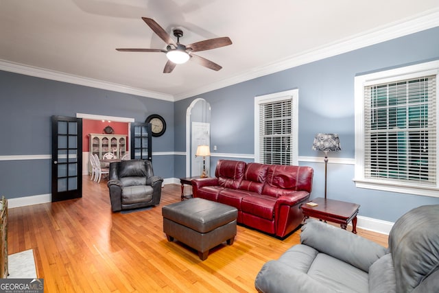 living room with ceiling fan, crown molding, and wood-type flooring