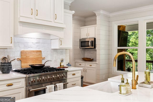 kitchen with sink, tasteful backsplash, stainless steel appliances, and white cabinets