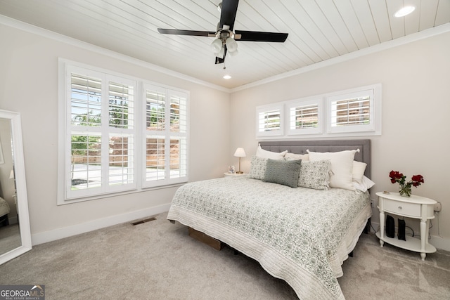 carpeted bedroom with ceiling fan, crown molding, and wooden ceiling