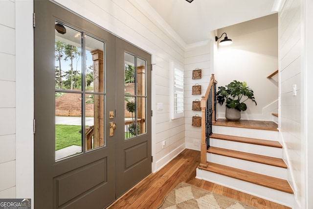 foyer entrance with dark hardwood / wood-style floors and wooden walls