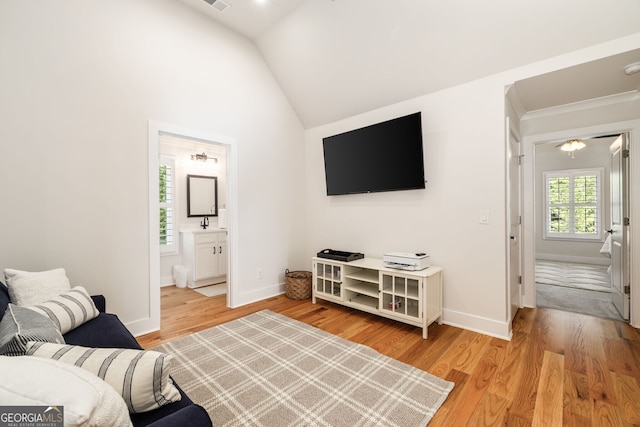 living room featuring sink, vaulted ceiling, and light hardwood / wood-style floors