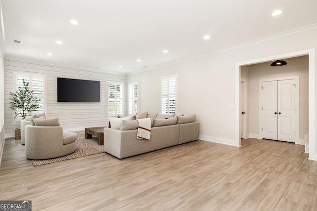 living room with ornamental molding and light hardwood / wood-style floors