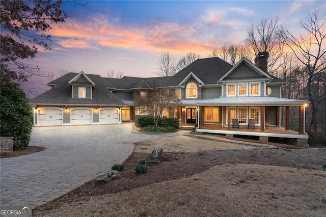 view of front of property with decorative driveway, covered porch, and a garage