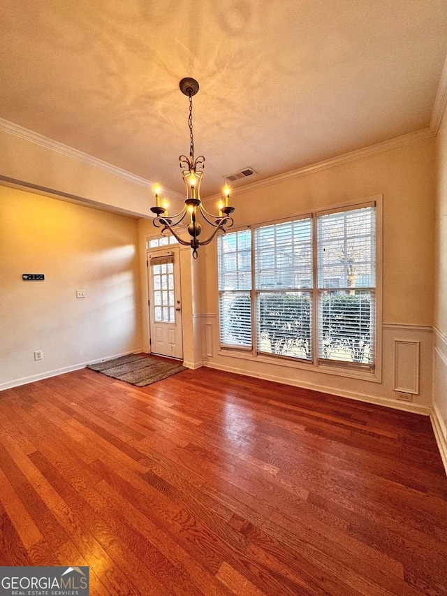 interior space featuring hardwood / wood-style flooring, crown molding, and a chandelier