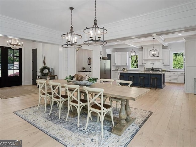 dining area with light hardwood / wood-style flooring, crown molding, a chandelier, and beam ceiling