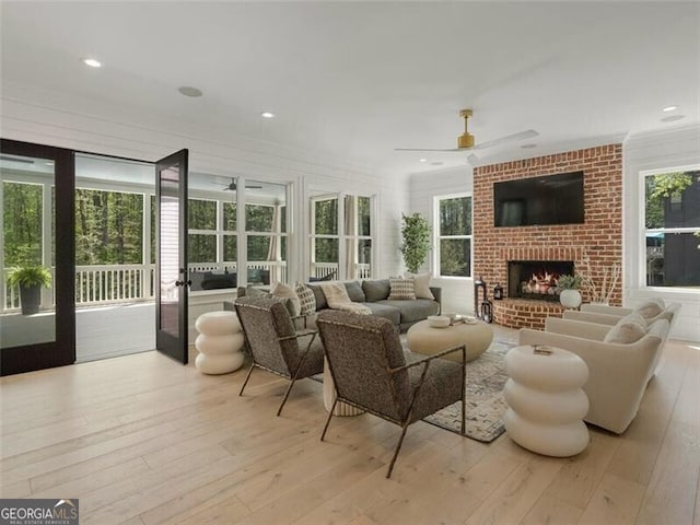 sunroom with plenty of natural light, ceiling fan, and a fireplace