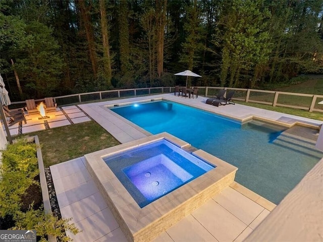 view of pool with an outdoor fire pit, a lawn, a patio area, and an in ground hot tub