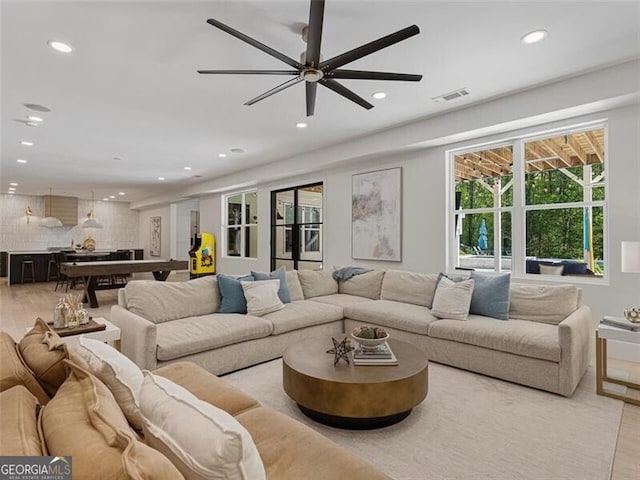 living room featuring ceiling fan and light hardwood / wood-style flooring