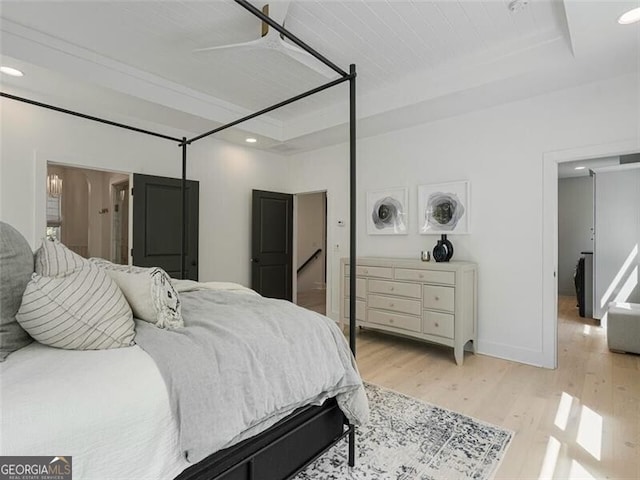 bedroom featuring a raised ceiling and light hardwood / wood-style floors