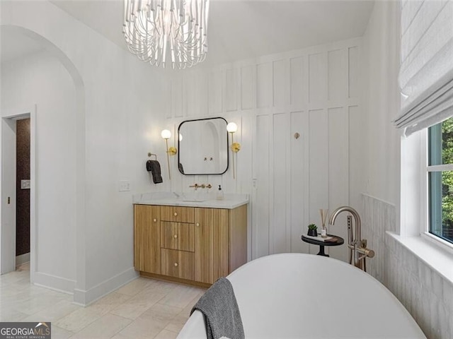 bathroom featuring vanity, an inviting chandelier, and a bathtub