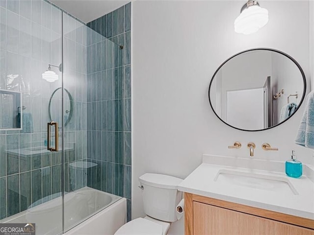 full bathroom featuring toilet, combined bath / shower with glass door, and vanity