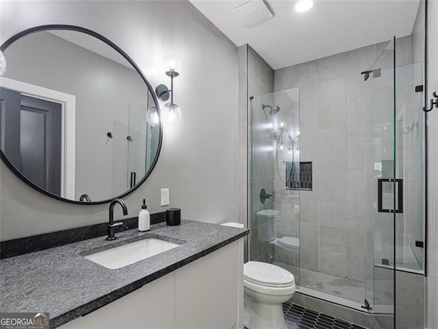 bathroom featuring an enclosed shower, vanity, and toilet