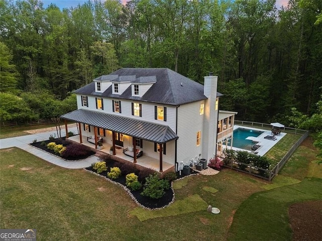 view of front of house featuring central air condition unit, a patio, and a front yard