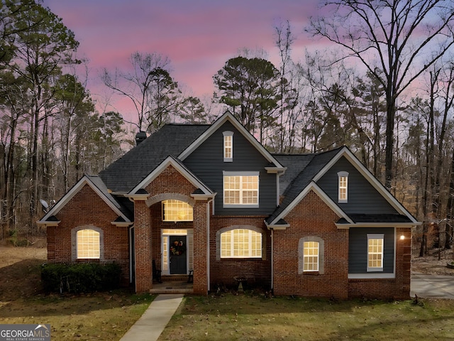 view of front of property with brick siding and a front lawn