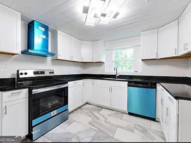 kitchen featuring appliances with stainless steel finishes, white cabinetry, wall chimney exhaust hood, and sink