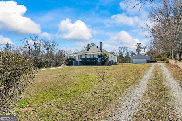 view of front of house with a front yard, a garage, and an outdoor structure