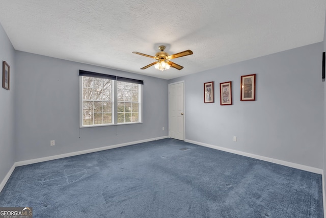 carpeted spare room featuring ceiling fan and a textured ceiling