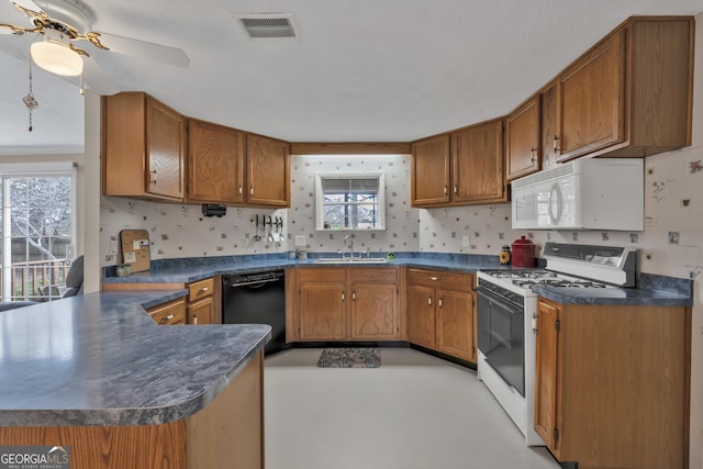 kitchen with white appliances, ceiling fan, sink, and kitchen peninsula