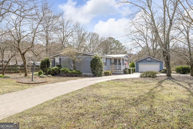 single story home with covered porch, a front lawn, an outdoor structure, and a garage