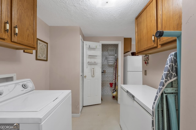 washroom featuring washer / clothes dryer, cabinets, and a textured ceiling