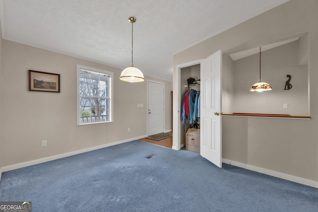 interior space featuring a textured ceiling, vaulted ceiling, and dark carpet