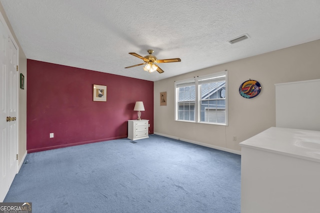 unfurnished room featuring carpet floors, a textured ceiling, and ceiling fan